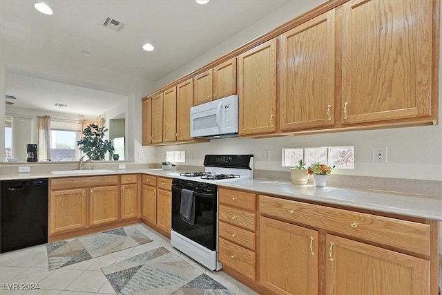 kitchen featuring sink, light tile patterned floors, and white appliances