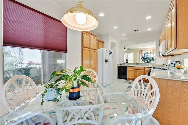 tiled dining room with ceiling fan and sink