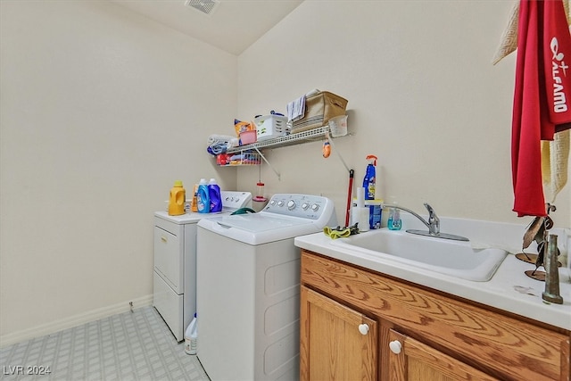 laundry area with cabinets, washer and clothes dryer, and sink