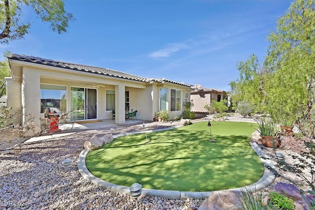 back of property featuring ceiling fan and a patio area