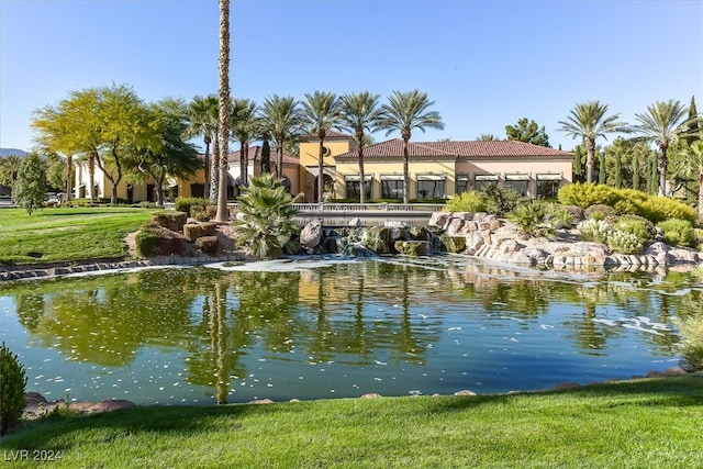 view of home's community with a water view and a yard