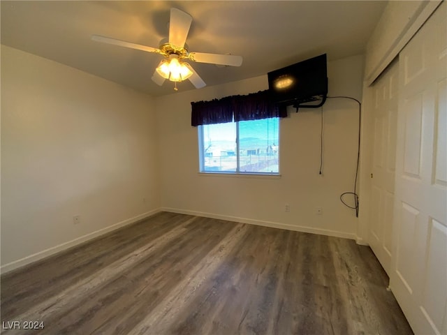 spare room with dark hardwood / wood-style flooring and ceiling fan