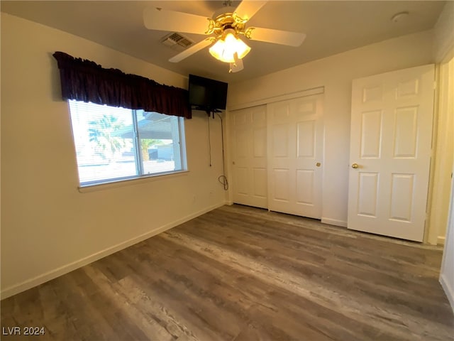 unfurnished bedroom with hardwood / wood-style floors, ceiling fan, and a closet