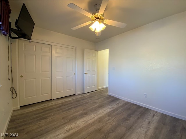 unfurnished bedroom with ceiling fan, a closet, and dark hardwood / wood-style floors