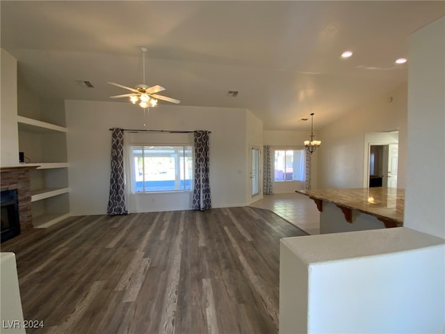 unfurnished living room with vaulted ceiling, a fireplace, plenty of natural light, and dark hardwood / wood-style flooring