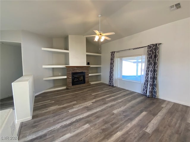 unfurnished living room with ceiling fan, vaulted ceiling, dark hardwood / wood-style flooring, and built in shelves