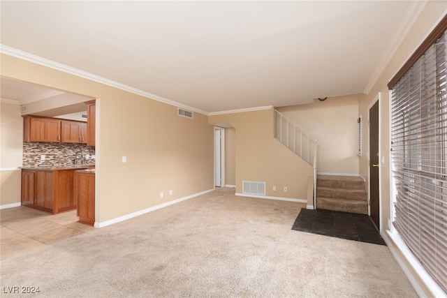 unfurnished living room with crown molding and light colored carpet