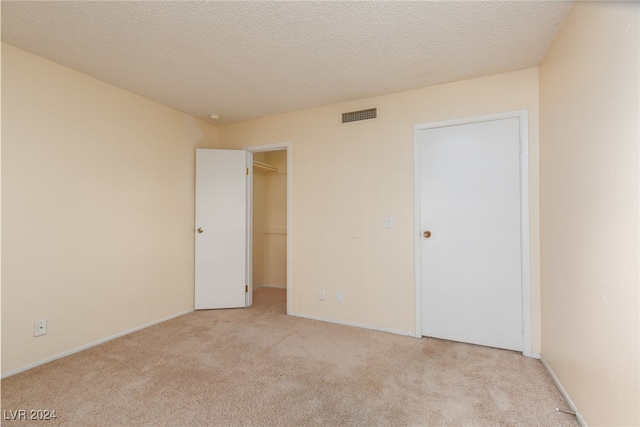 carpeted spare room with a textured ceiling