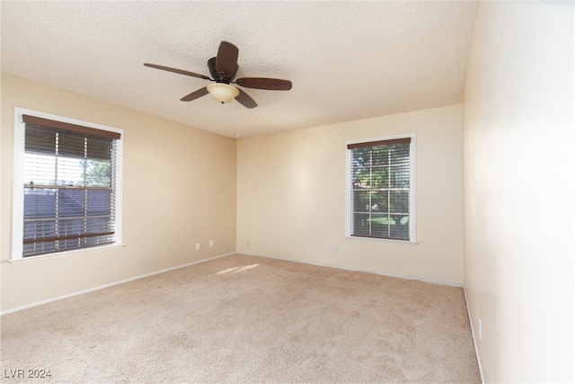 unfurnished room featuring light colored carpet, ceiling fan, and a textured ceiling