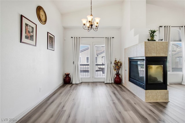 interior space featuring light hardwood / wood-style floors, vaulted ceiling, and a chandelier