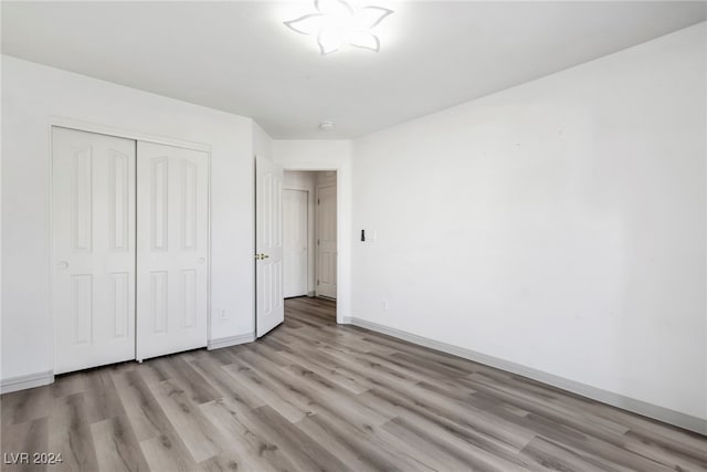 unfurnished bedroom featuring a closet and light hardwood / wood-style floors