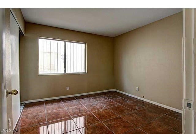 empty room featuring dark tile patterned floors