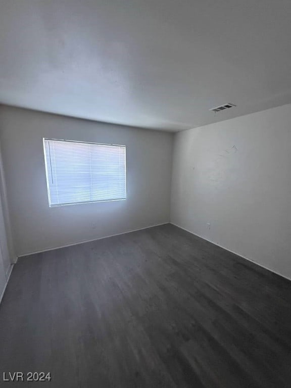 unfurnished room with dark wood-type flooring