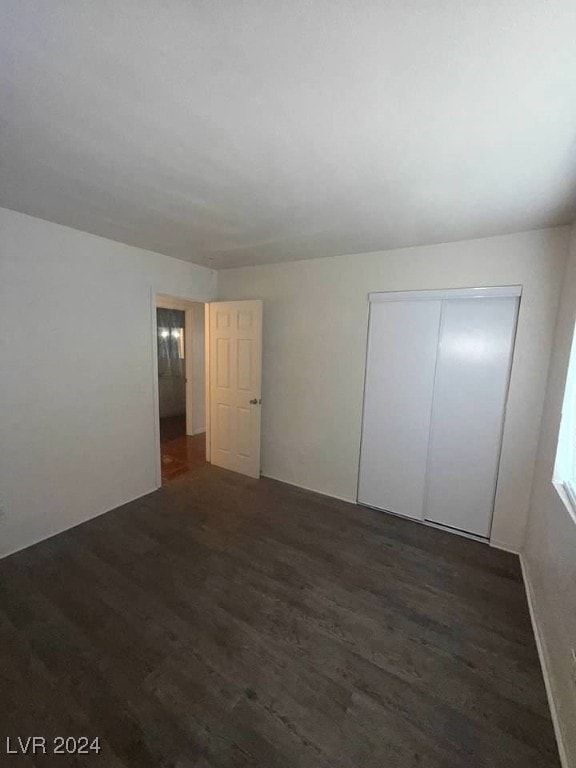 unfurnished bedroom featuring dark hardwood / wood-style floors and a closet