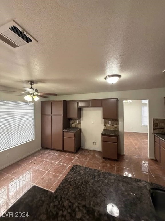 kitchen featuring ceiling fan, tile patterned flooring, and a textured ceiling