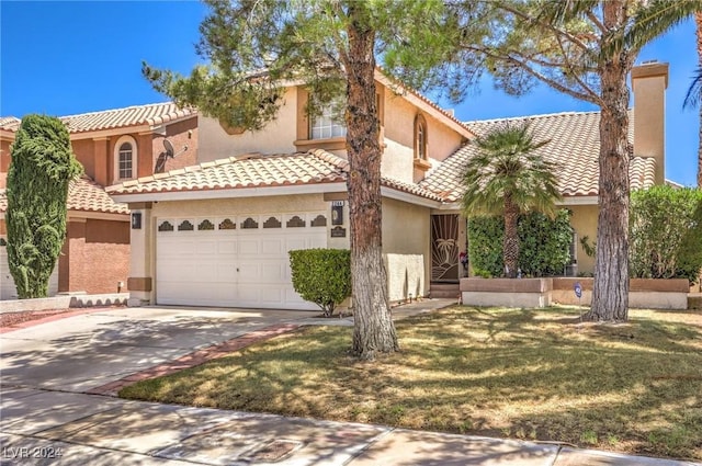 mediterranean / spanish-style home featuring a front yard and a garage