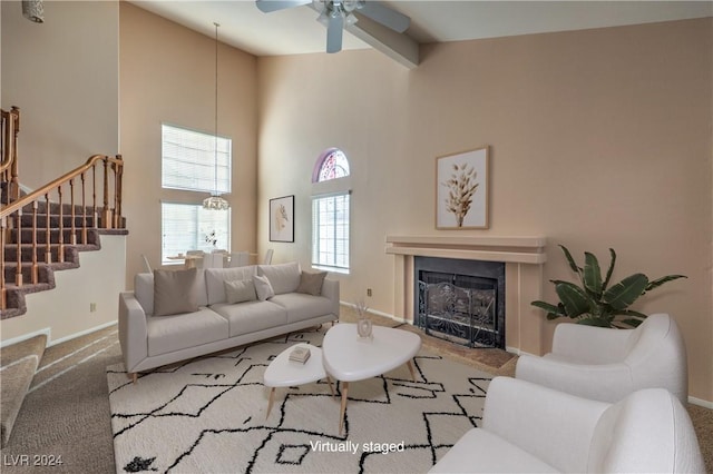 carpeted living room with beam ceiling, ceiling fan, and high vaulted ceiling