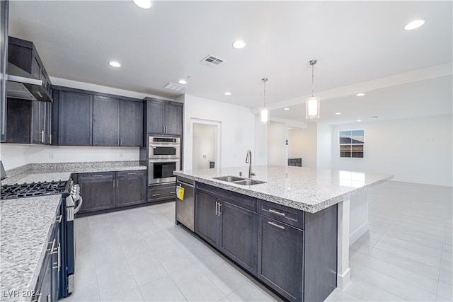 kitchen featuring sink, an island with sink, stainless steel appliances, decorative light fixtures, and light stone counters