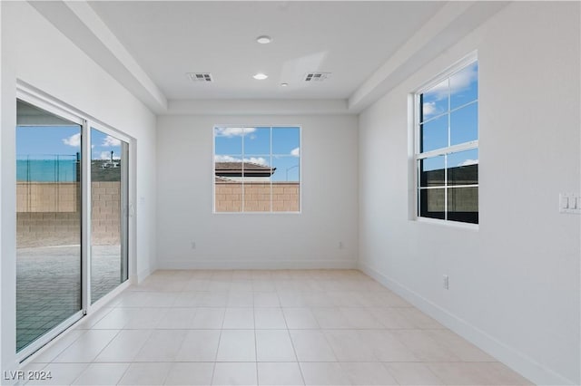 spare room featuring a wealth of natural light and light tile patterned floors