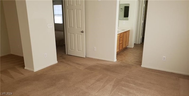 unfurnished bedroom with connected bathroom and light carpet