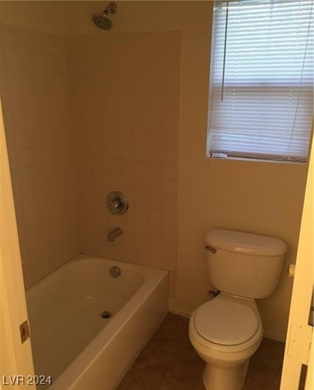 bathroom with tile patterned flooring, toilet, and tiled shower / bath combo