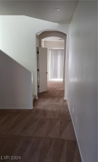 hallway with dark colored carpet