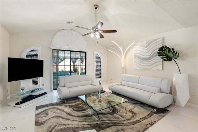 living room with ceiling fan, vaulted ceiling, and light tile patterned floors