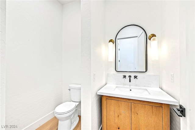 bathroom with vanity, hardwood / wood-style floors, and toilet