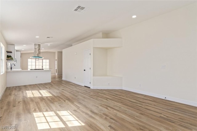 unfurnished living room featuring light hardwood / wood-style flooring and sink