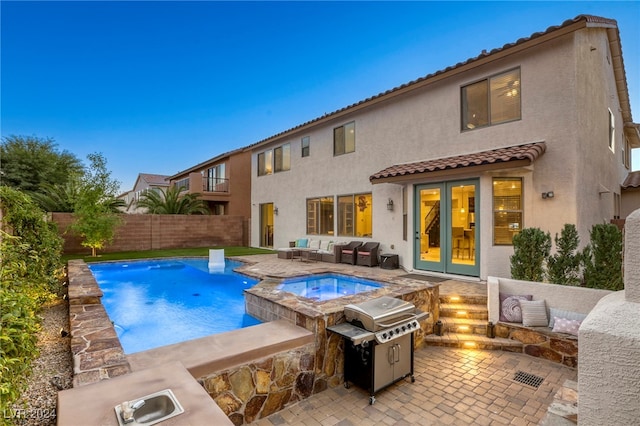 view of swimming pool featuring french doors, a patio, an in ground hot tub, and a grill