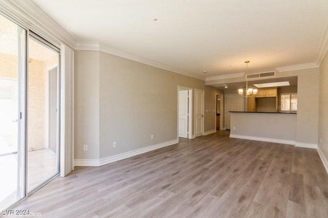 unfurnished living room with wood-type flooring, ornamental molding, and a chandelier