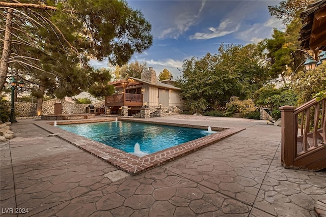 view of pool with a patio and pool water feature