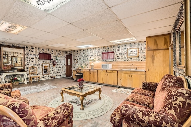 living room featuring a paneled ceiling and sink