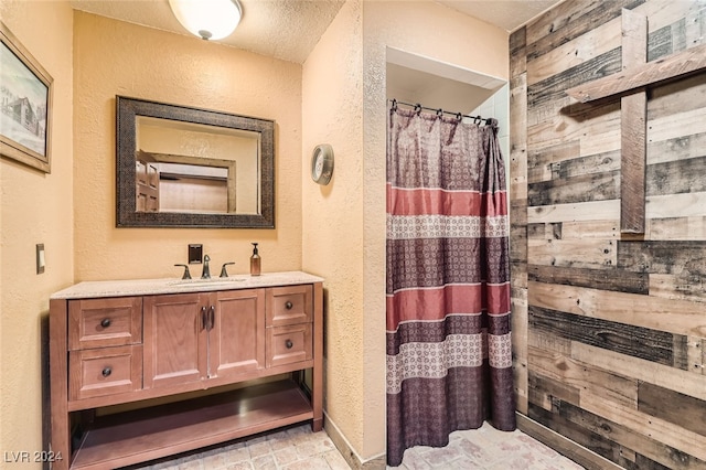 bathroom featuring walk in shower, vanity, and a textured ceiling