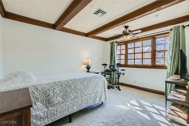 carpeted bedroom with ceiling fan and beam ceiling