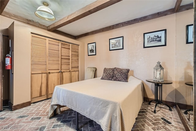 bedroom featuring a closet and beam ceiling