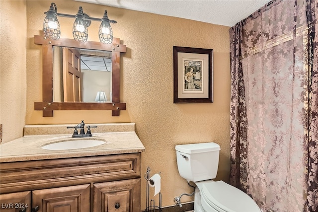 bathroom featuring a textured ceiling, a shower with curtain, vanity, and toilet