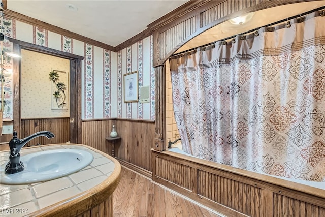 bathroom featuring shower / bath combo with shower curtain, sink, and wood-type flooring