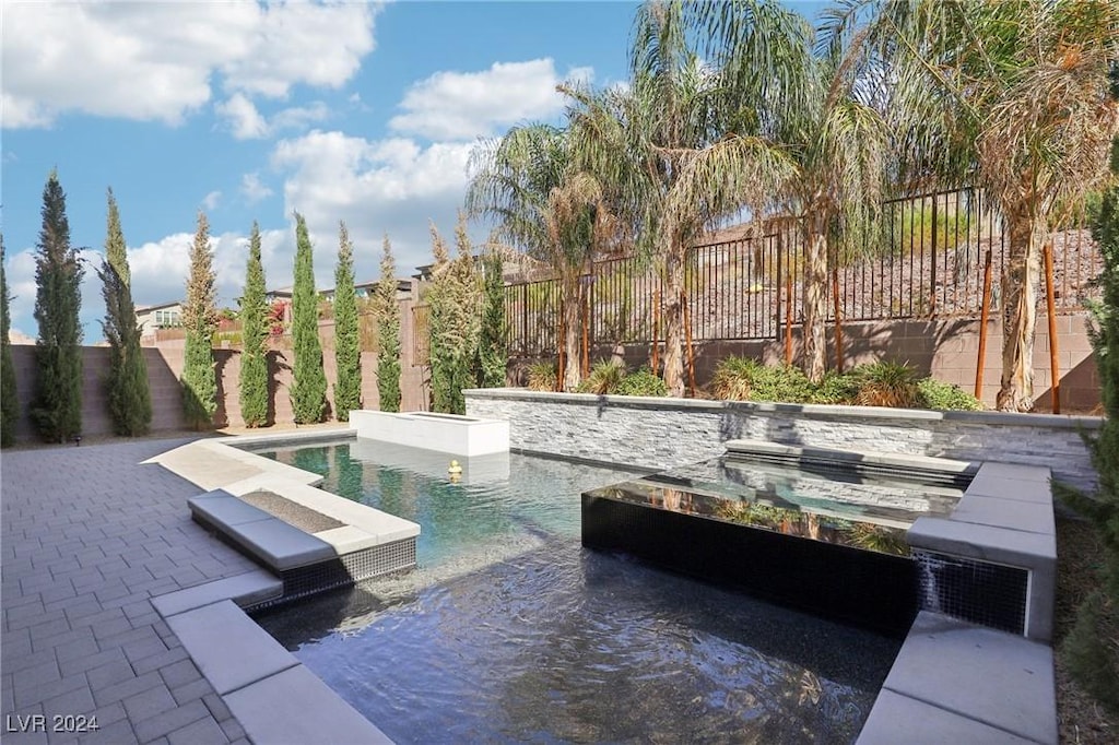 view of swimming pool with a patio area and a hot tub