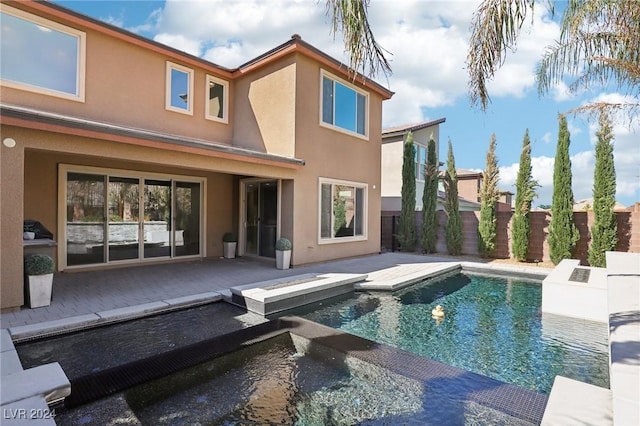 rear view of property featuring a fenced in pool