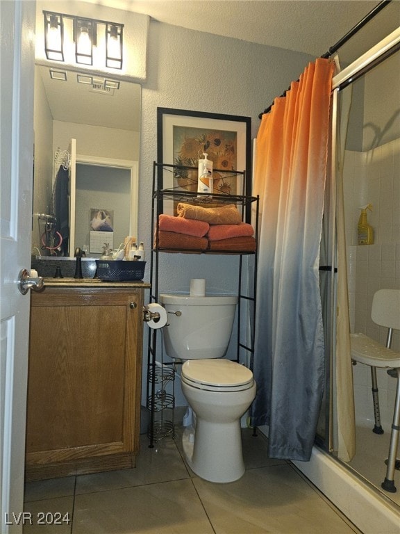 bathroom with vanity, tile patterned flooring, toilet, and curtained shower