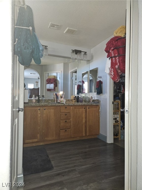 interior space featuring vanity, hardwood / wood-style floors, and a textured ceiling