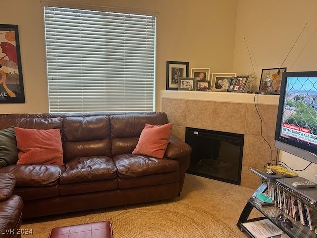 living room with light tile patterned flooring and a tiled fireplace