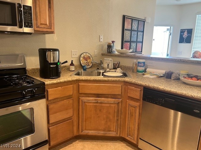 kitchen with light tile patterned flooring, appliances with stainless steel finishes, and sink