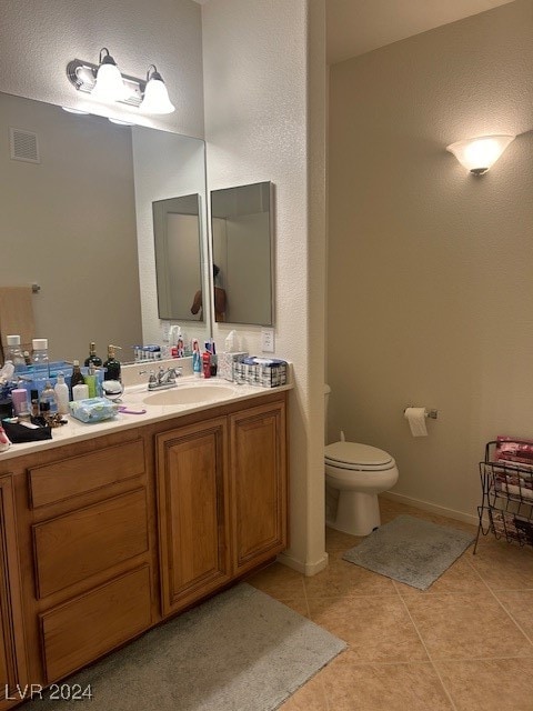 bathroom with tile patterned flooring, vanity, and toilet