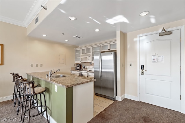 kitchen featuring white appliances, sink, kitchen peninsula, a breakfast bar area, and light colored carpet