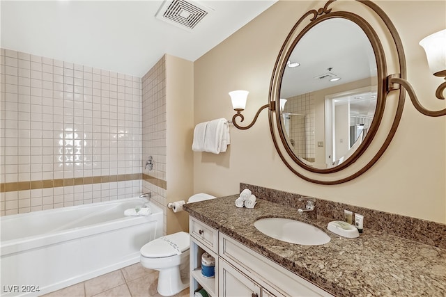 full bathroom featuring tiled shower / bath, vanity, toilet, and tile patterned floors