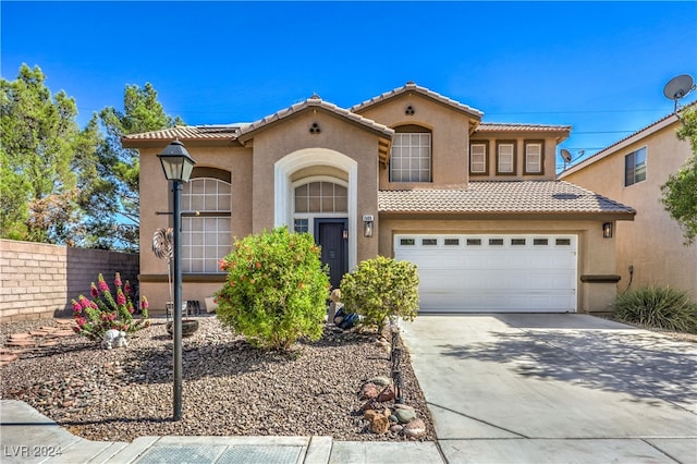 mediterranean / spanish-style home with a garage