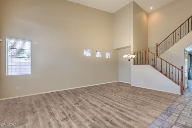 unfurnished living room with a high ceiling and light hardwood / wood-style flooring