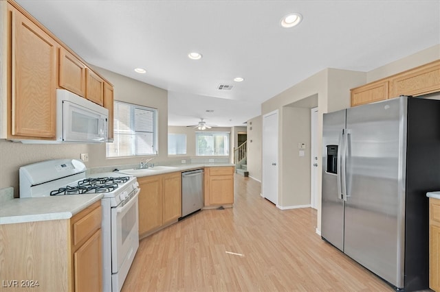 kitchen with light brown cabinets, appliances with stainless steel finishes, light wood-type flooring, and sink